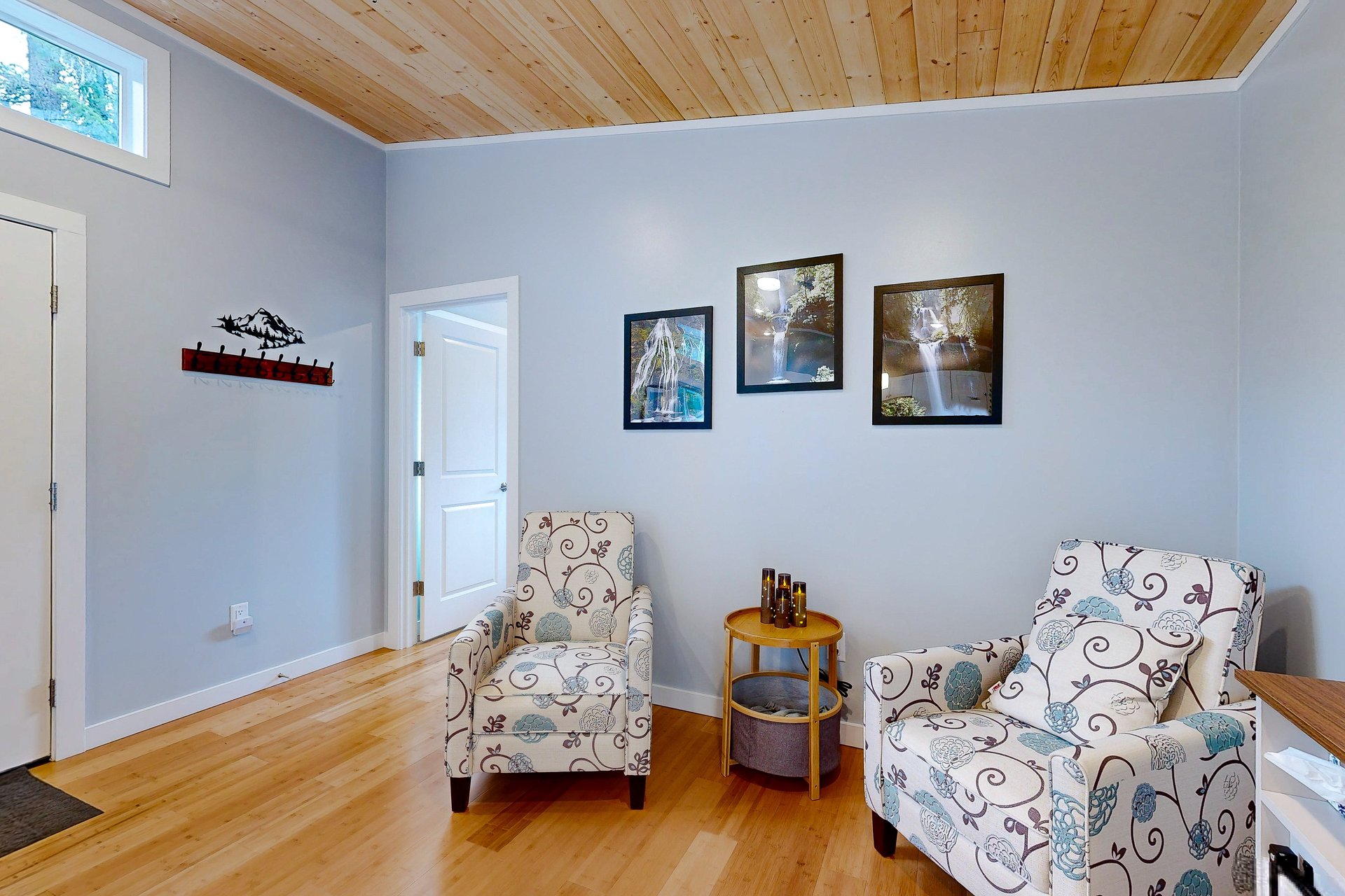 Living room entry with coat hooks and waterfall artwork